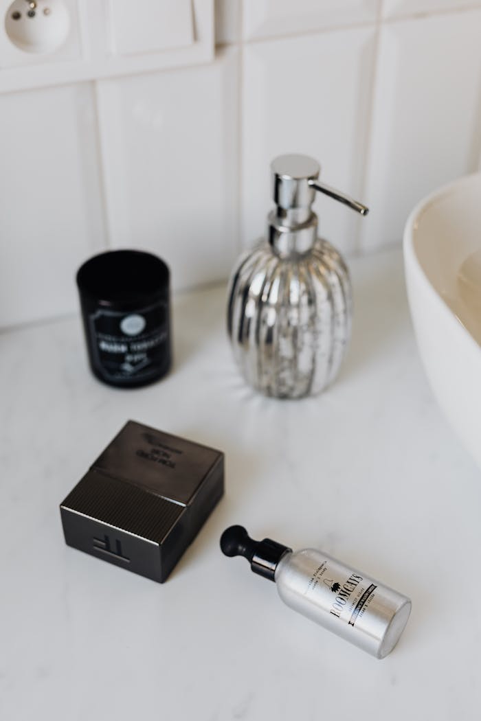 From above stylish set of male perfume and cosmetic products placed on marble surface near sink in bathroom